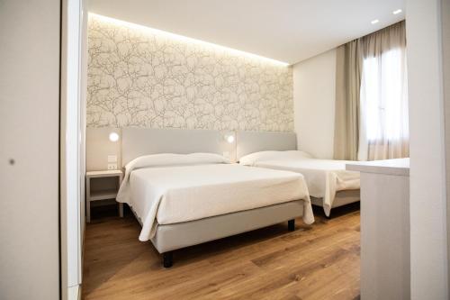 um quarto com 2 camas e uma parede com papel de parede em Feel Good em Rimini