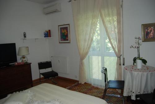 ローマにあるLa Badia del Cavaliereのベッドルーム1室(ベッド1台、テーブル、窓付)