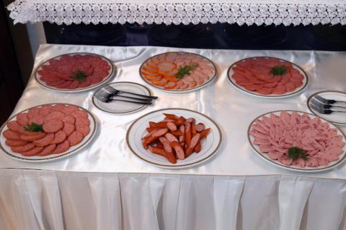 a table topped with different types of meats and carrots at Asia Hotel Fergana in Fergana