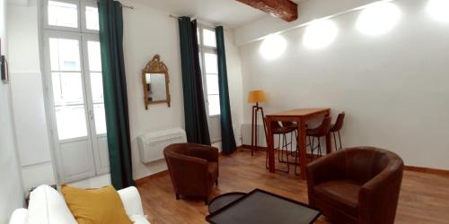 ein Wohnzimmer mit einem Sofa, Stühlen und einem Tisch in der Unterkunft Le musée Fabre, climatisation , parking gratuit in Montpellier