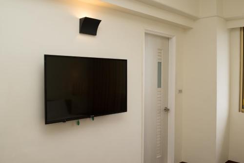 a flat screen tv hanging on a white wall at Bowa Hotel Penghu in Magong