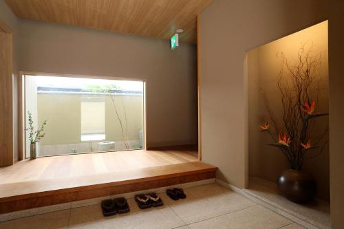 Zimmer mit einem großen Fenster mit Schuhen auf dem Boden in der Unterkunft Maru Izumiyacho in Kyoto