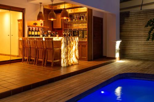a bar and a swimming pool in a restaurant at The Giglio Boutique Hotel at Zevenster in Johannesburg