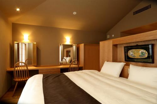 sypialnia z łóżkiem, biurkiem i lustrem w obiekcie Maru Izumiyacho w mieście Kioto