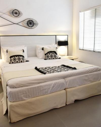 a large bed in a white room with a large bed sidx sidx at Angelos Design Suites in Patitiri