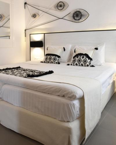 a large white bed with two pillows on it at Angelos Design Suites in Patitiri