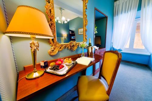 a desk with a lamp and a plate of food on it at Hotel Scalinata Di Spagna in Rome