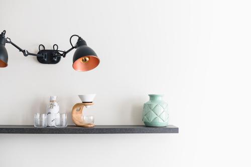 a shelf with lights and vases on it at ROXI The Urban Residence Brussels in Brussels