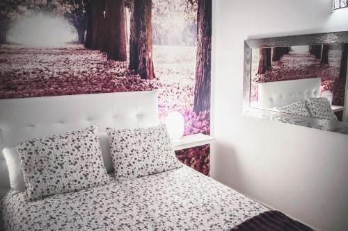 1 dormitorio con 1 cama con una foto en la pared en Alojamiento Lirio, Céntrico y cerca de la Playa en Vilanova i la Geltrú