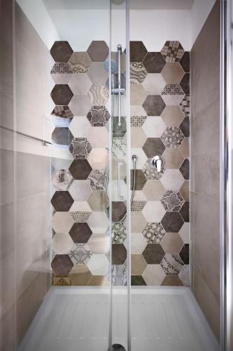 a shower with a glass door in a bathroom at Vela Rooms in Cagliari