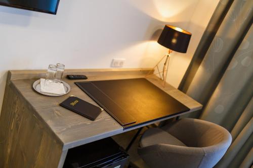 a desk with a lamp and a book on it at Restaurace a penzion Pod Lipami Metylovice in Metylovice