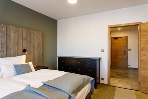 a bedroom with a large bed with a wooden headboard at Restaurace a penzion Pod Lipami Metylovice in Metylovice