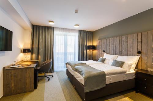 a bedroom with a large bed and a desk and a desk at Restaurace a penzion Pod Lipami Metylovice in Metylovice