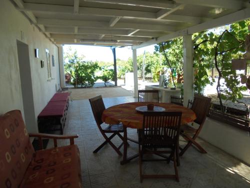 a patio with a table and chairs on a porch at Silence of the Birds in Olhão