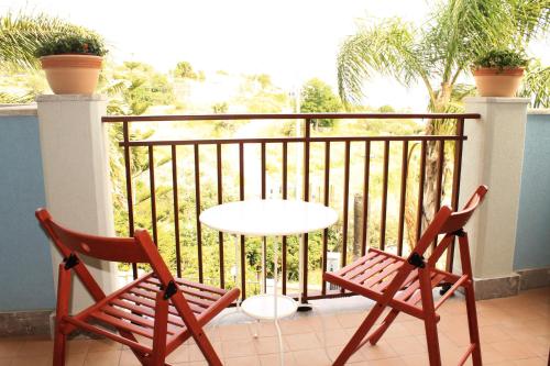 two chairs and a table on a balcony at Villa i Minnulareddi in Giardini Naxos