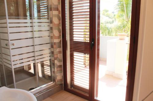 a room with a sliding glass door with shutters at Villa i Minnulareddi in Giardini Naxos