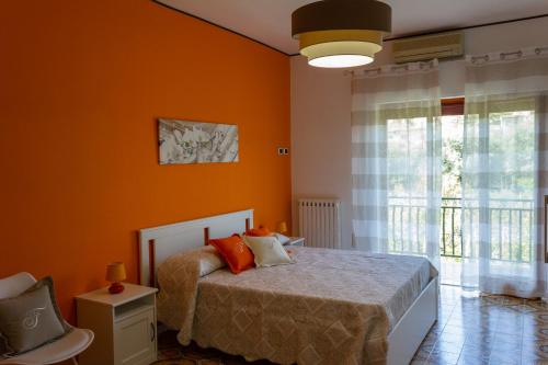 Schlafzimmer mit orangefarbenen Wänden, einem Bett und einem Fenster in der Unterkunft Flower's Home in Sorrent
