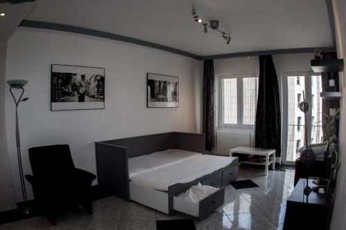 1 dormitorio con 1 cama y 1 silla en Deák design apartment, en Budapest