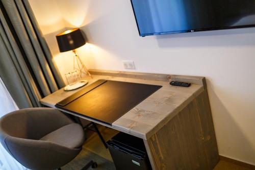 a desk in a room with a chair and a lamp at Restaurace a penzion Pod Lipami Metylovice in Metylovice