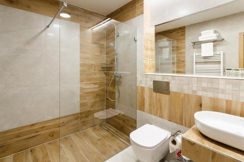 a bathroom with a shower and a toilet and a sink at Restaurace a penzion Pod Lipami Metylovice in Metylovice