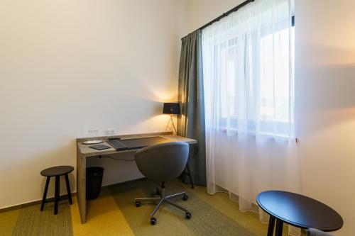 a room with a desk and two chairs and a window at Restaurace a penzion Pod Lipami Metylovice in Metylovice