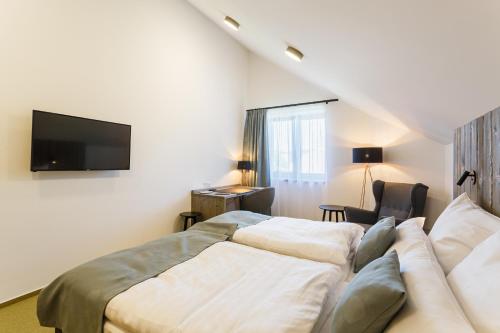 a hotel room with two beds and a flat screen tv at Restaurace a penzion Pod Lipami Metylovice in Metylovice