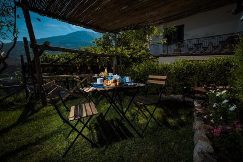 a table and chairs in a yard with a view at B&B La Gemma di Ravello in Ravello