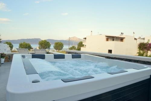 a hot tub on the roof of a house at Ostria Hotel  in Adamas