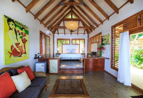 a bedroom with a bed and a couch in a room at Savasi Island Resort in Savusavu