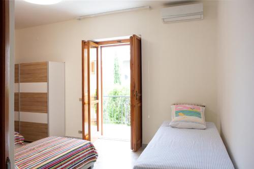 una camera con letto e porta scorrevole in vetro di Villa Franca Mini Appartamenti a Bisceglie