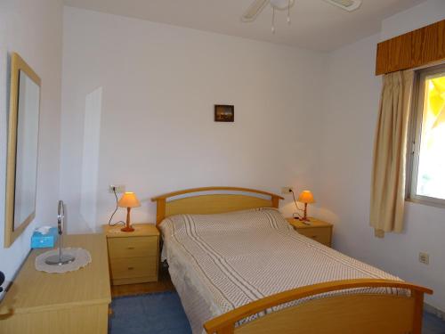 1 dormitorio con 1 cama, 2 mesas y 2 lámparas en Brisas del Mar Azul, en Torrevieja