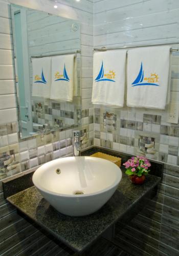a bathroom with a large white sink and towels at Mui Tau Hotel Phan Ri Cua in Tuy Phong