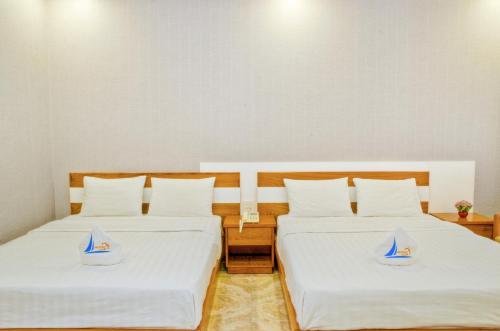 two beds in a room with boats on them at Mui Tau Hotel Phan Ri Cua in Tuy Phong