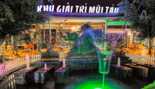a fountain in front of a restaurant at night at Mui Tau Hotel Phan Ri Cua in Tuy Phong
