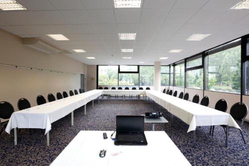 a conference room with white tables and chairs and a laptop at Caravelle Hotel im Park in Bad Kreuznach