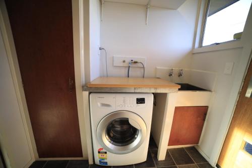 een wasmachine en droger in een tiny house bij Rejuvenate on Rata FREE WIFI in Twizel