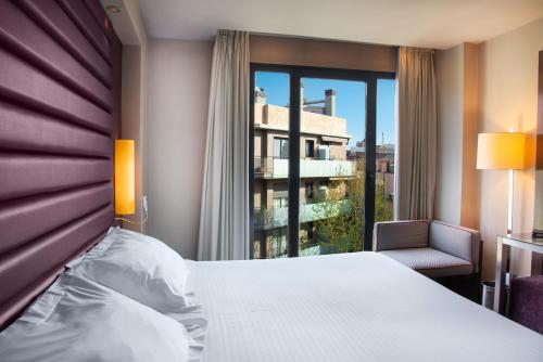a hotel room with a bed and a window at Pestana Arena Barcelona in Barcelona