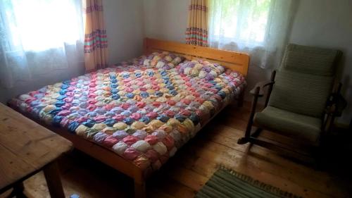 a bed with a colorful comforter in a bedroom at Kačiūniškis in Kaciūniškiai
