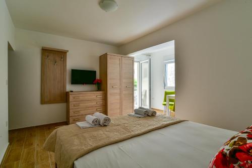 a bedroom with a large bed with towels on it at Apartmani Marina Kopitovic in Petrovac na Moru
