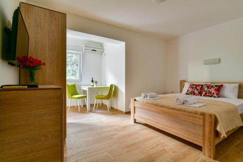 a bedroom with a bed and a desk and a table at Apartmani Marina Kopitovic in Petrovac na Moru