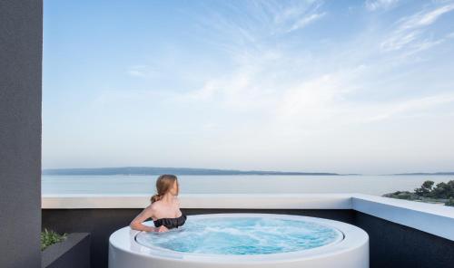 a woman sitting in a hot tub on a balcony at briig boutique hotel in Split