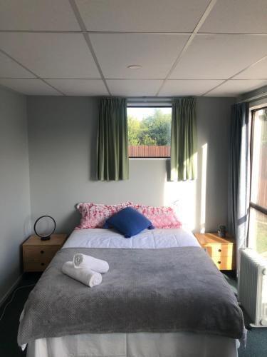 a bedroom with a bed with two towels on it at West Lake Holiday Home in Christchurch