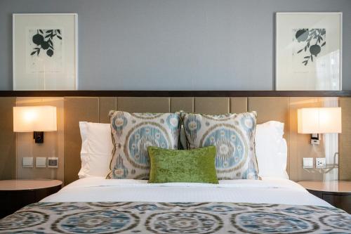 a bedroom with a large bed with two pillows at Ascott Makati in Manila