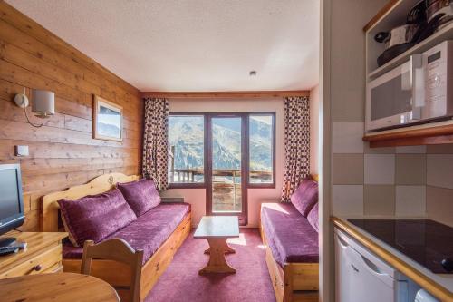 - un salon avec des canapés violets et une fenêtre dans l'établissement Residence Le Douchka - maeva Home, à Avoriaz