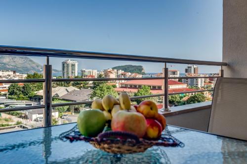 a bowl of fruit on a table with a view of a city at Adriatik Lux Apartments in Budva