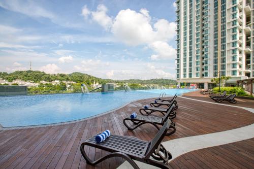 a row of benches sitting next to a swimming pool at Mercure Living Putrajaya in Putrajaya