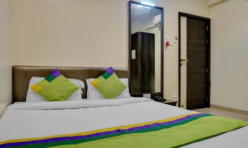 a bedroom with a large white bed with colorful pillows at Treebo Bhagyashree Executive in Pune