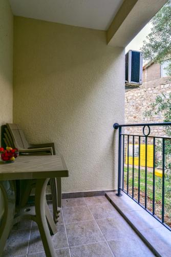 a porch with a table and chairs and a fence at Apartmani Marina Kopitovic in Petrovac na Moru