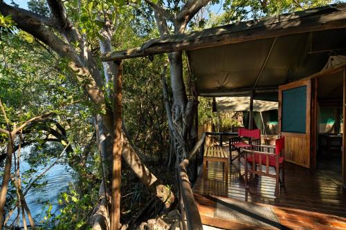 a porch of a house with a table and chairs at Ichingo Chobe River Lodge by Mantis in Punga