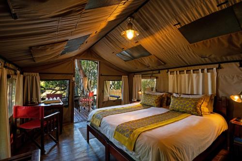 PungaにあるIchingo Chobe River Lodge by Mantisのベッドルーム1室(ベッド1台、テーブル、椅子付)